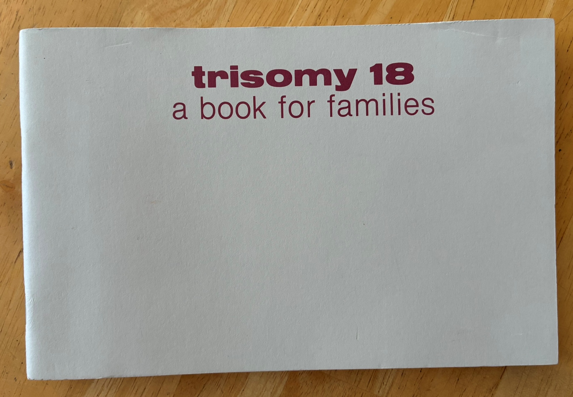 Cover of "Trisomy 18: A Book for Families," a light grey paperback co-authored by Kris Carr Lowry and Dr. John C. Carey — the first family resource guide of its kind, published in the early 1980s.