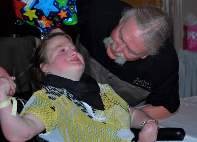 Stacy VanHerreweghe as a young child with Trisomy 18 Edwards syndrome in her pink outfit — Brockport New York