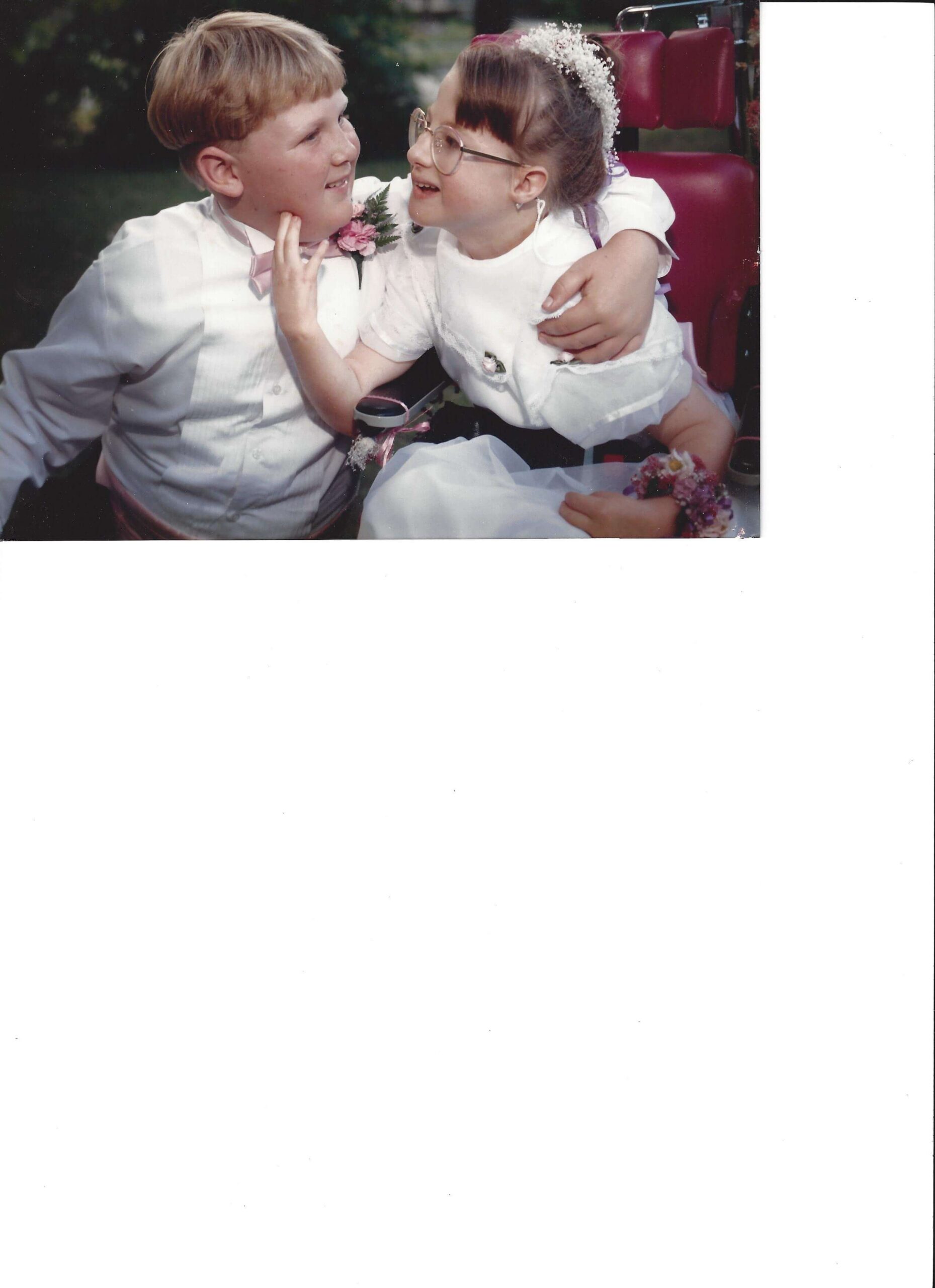 Stacy VanHerreweghe with Trisomy 18 Edwards syndrome as a child smiling in pink